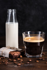 coffee, milk in glass bottle and homemade brownie cake on wooden tabletop