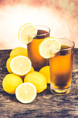 lemon ice tea on wooden table with lemons around