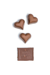 top view of heart shaped candies and piece of chocolate bar isolated on white
