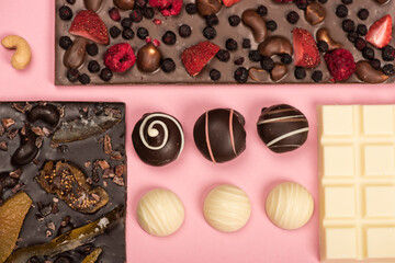 flat lay with assorted chocolate bars with fruits and nuts and candies isolated on pink