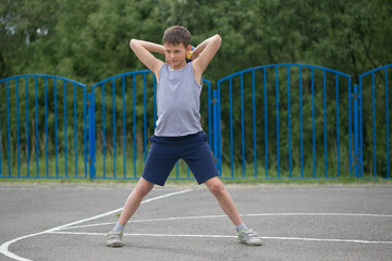 Fototapeta premium Teenager in a T-shirt and shorts playing with a ball