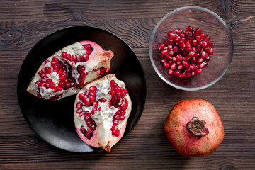 red pomegranate sliced fruit on wooden background top view