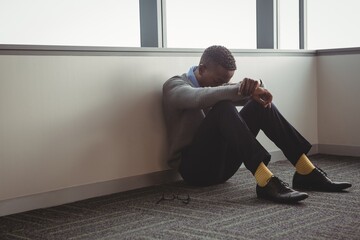 Sad executive sitting on floor