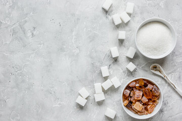 variety of sugar in bowls on gray table background top view space for text