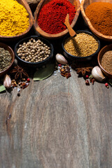 assortment of spices on a wooden background, vertical