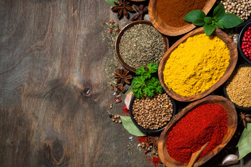 assortment of various spices and herbs on a wooden table, top view