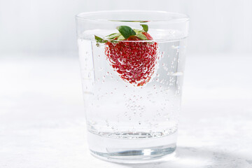 glass of carbonated water with fresh strawberries