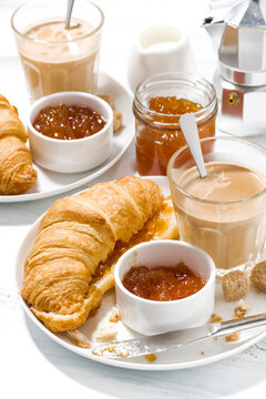 croissants with jam and coffee with milk for breakfast, vertical