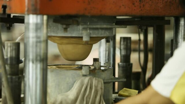 Special machine for utensils bowls under production process in a factory.