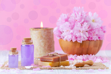 lavender oil, soap, salt, fresh flowers, candle, on pink, for spa and wellness