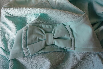 Folded bluish green fabric with bow and ribbon