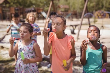 Schoolkids playing with bubble wand