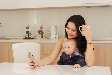 young mother and her son play and reading a book on sofa, lifestyle