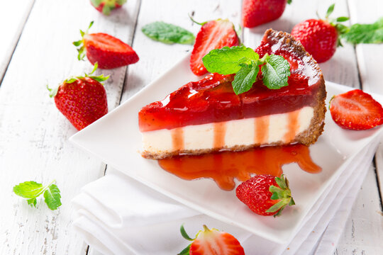 Delicious cheesecake with strawberries on wooden table.