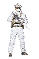 Special forces operator of Navy Seals armed with assault rifle with closed face in polarized sunglasses and military winter camo clothes designed to operations in extreme conditions. Studio shot