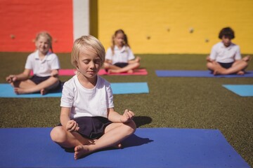 Schoolkids practicing yoga