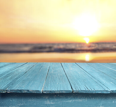 blue table top against blurred sunset beach background