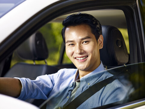 Young Asian Man Sitting In A Car Smiling