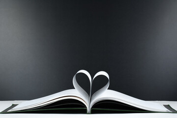Old open hardback book, page decorate into a heart shape for love in Valentine's. love with open book heart.