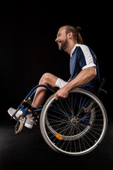 Fototapeta na wymiar happy paralympic in wheelchair dressed in sportswear isolated on black