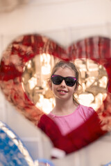 Obraz premium Funny portrait of little girl reflected in a mirror of heart