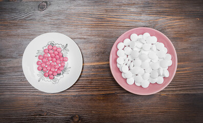 Pink and white tablets on a saucer
