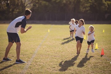 Coach monitoring schoolgirls during running competition