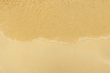 Soft wave on the beach. Summer season on empty tropical beach with waves and clear sand.