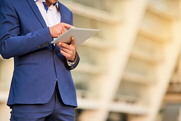 Man in suit using tablet. Businessman with a gadget. Business information systems. © DenisProduction.com