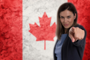 Beautiful businesswoman pointing her finger at you Canadian flag background.