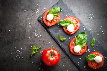 Traditional italian caprese salad on black/ Top view.