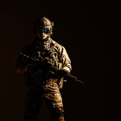Elite member of US Army rangers in combat helmet and night vision device. Studio shot, dark black...