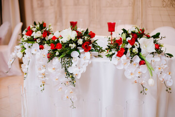 Newlyweds table decorated with gorgeous bouquet of orchid and roses