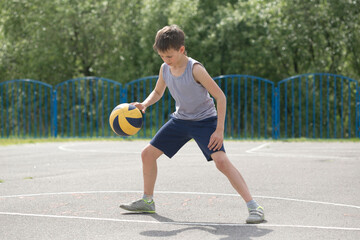 Teenager in a T-shirt and shorts playing with a ball