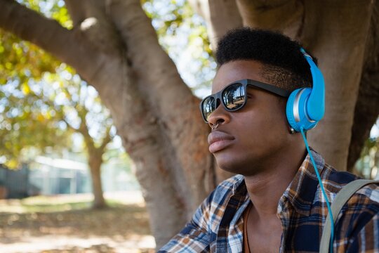 Young man in sunglasses and headphones listening to music
