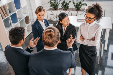 Fototapeta premium young coworkers in formalwear arguing at business meeting in office, business team meeting