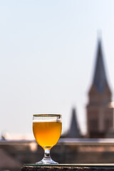 A glass of beer against the background of old buildings
