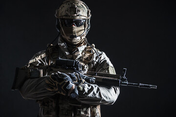 Army soldier in Protective Combat Uniform holding Special Operations Forces Combat Assault Rifle....