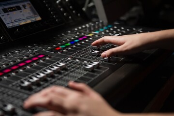 Hands of female audio engineer using sound mixer