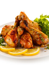 Roast chicken drumsticks on white background