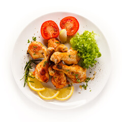 Roast chicken drumsticks on white background