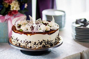 Obraz na płótnie Canvas Chocolate cake watered flowers stands on a table