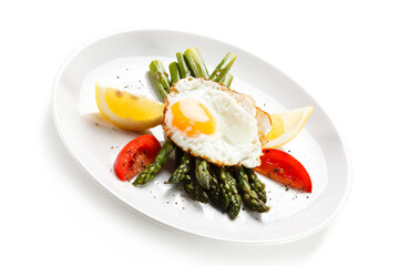 Fried egg with asparagus on white background
