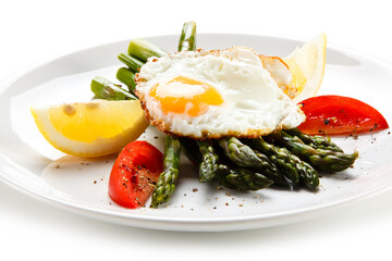 Fried egg with asparagus on white background