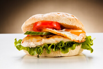Sandwich with fried egg and chicken fillet on white background