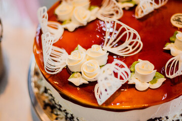 Obraz na płótnie Canvas Chocolate cake watered flowers stands on a table