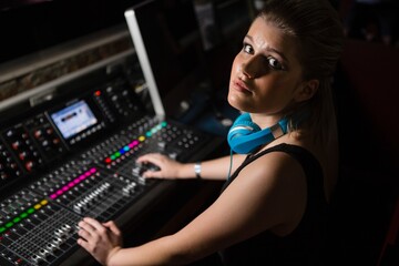 Female audio engineer using sound mixer