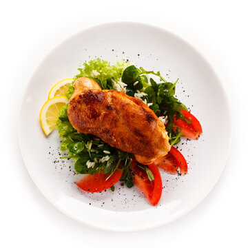 Grilled chicken fillet with vegetables on white background