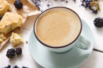 Latte coffee and flowers composition on white wood