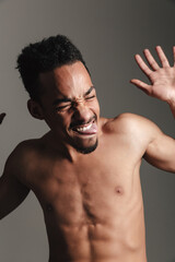 Fototapeta premium Young funny african man isolated over grey background